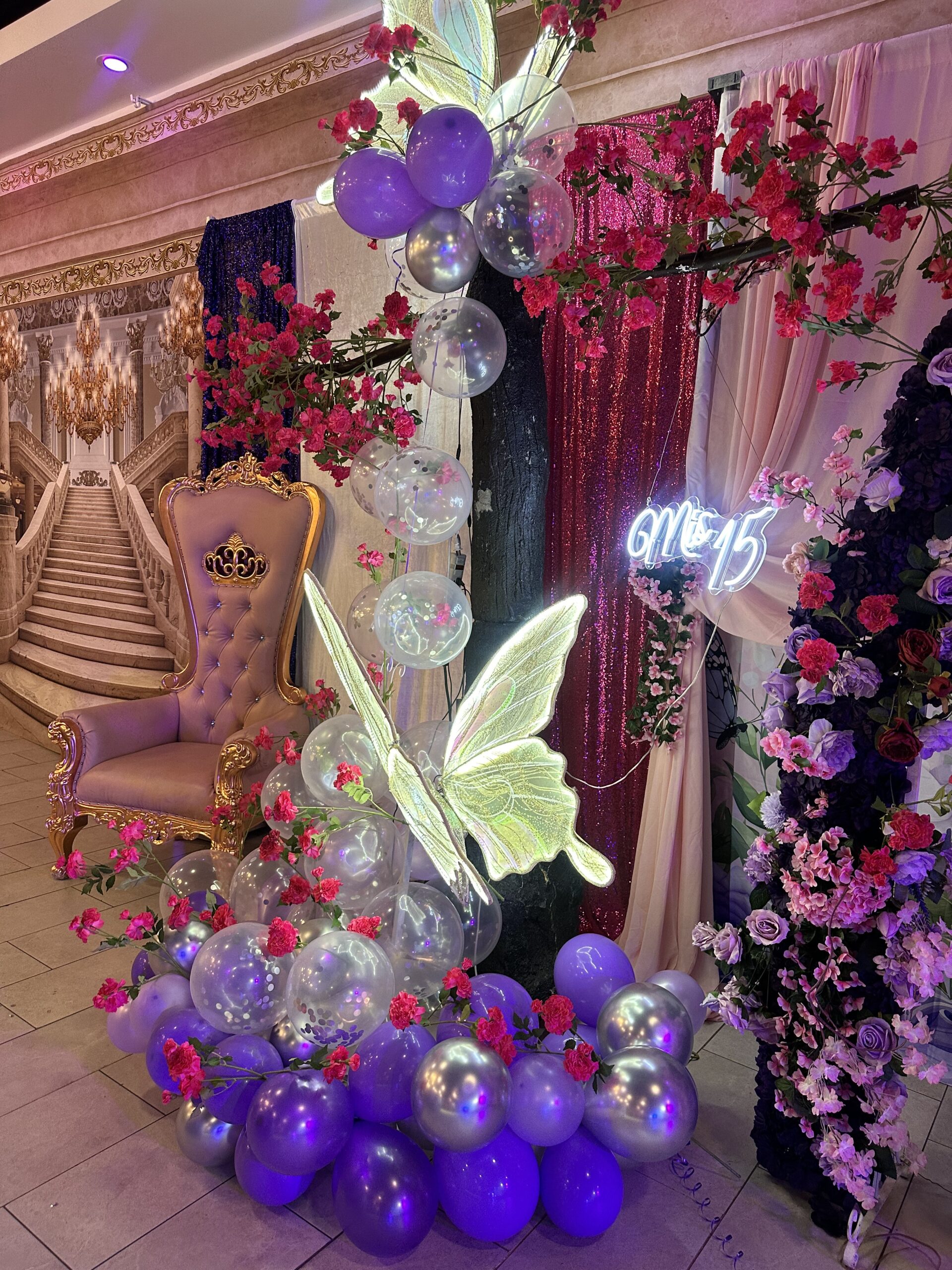 Quinceañera photo area with throne, neon Mis 15 sign, and balloon garland at Lavender Venue