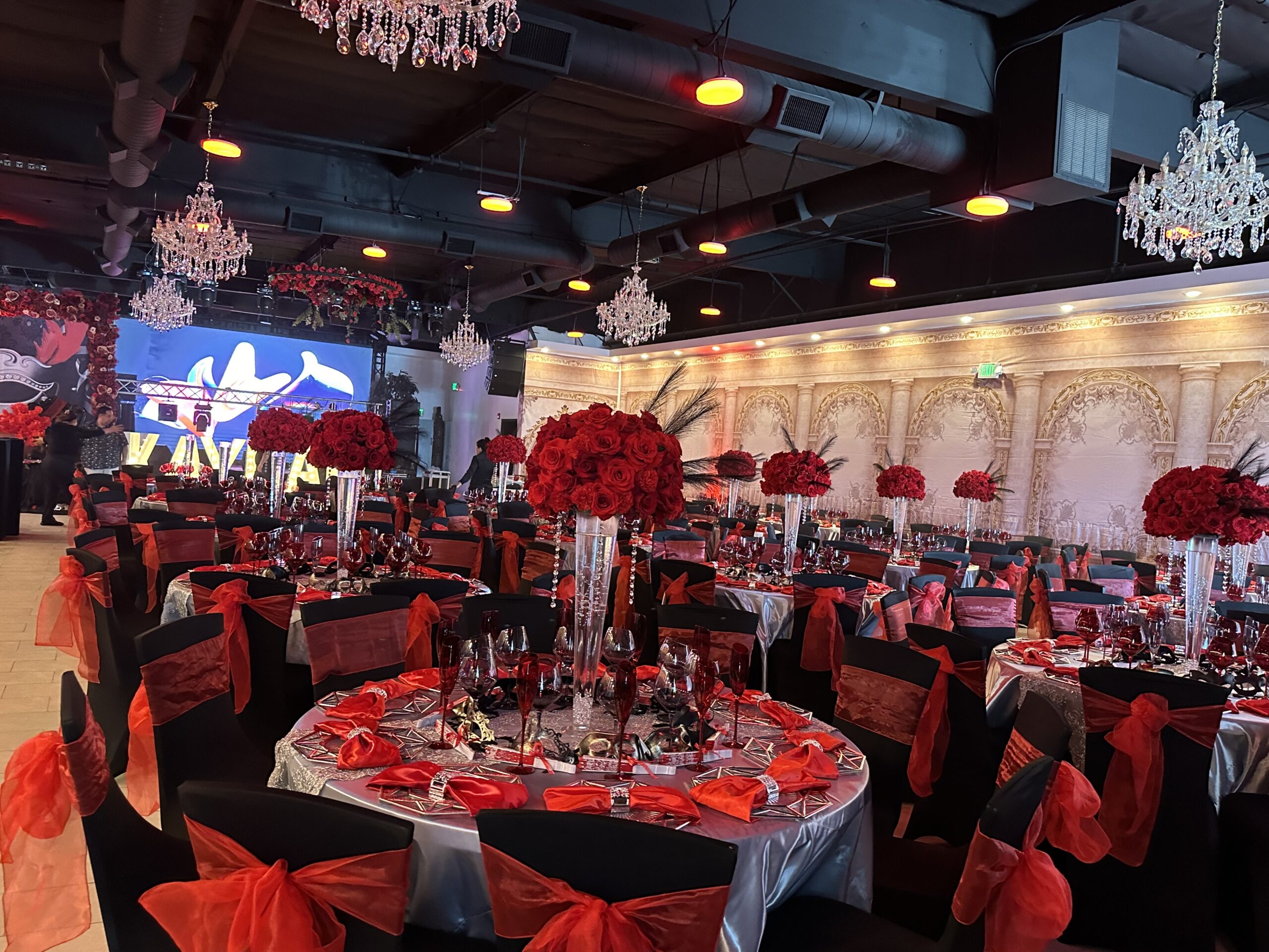 Dramatic red and black event setup with LED screen and crystal chandeliers at Lavender Venue